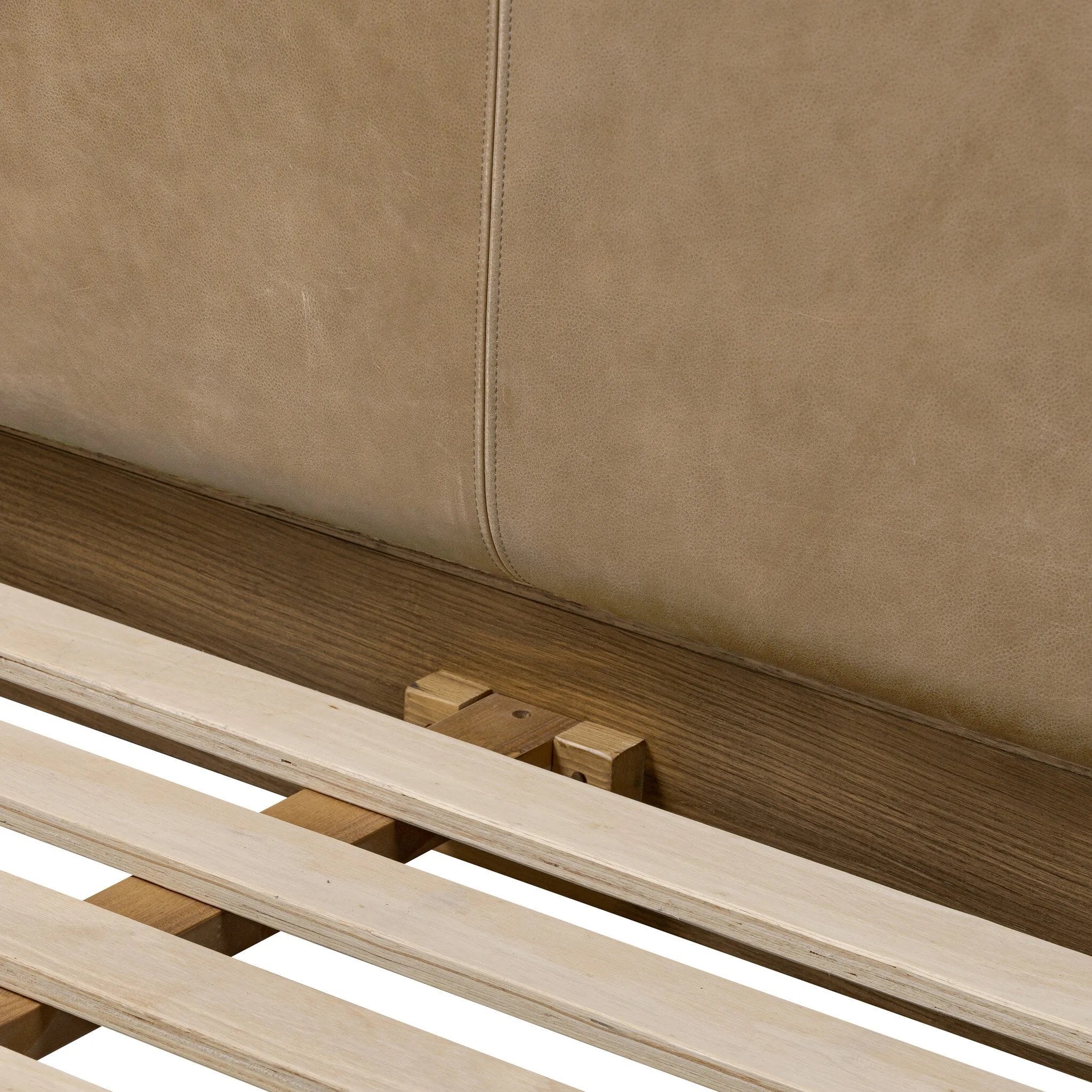 Rounded, chunky dowel legs in an amber oak finish frame the tan top-grain leather headboard of this simple-but-striking bed frame Amethyst Home provides interior design, new home construction design consulting, vintage area rugs, and lighting in the Omaha metro area.