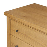 Create storage space in the bedroom with a five-drawer dresser of amber-finished oak. Chunky dowel legs support a tall silhouette and overhang top, all finished out with simple gunmetal hardware Amethyst Home provides interior design, new home construction design consulting, vintage area rugs, and lighting in the Seattle metro area.