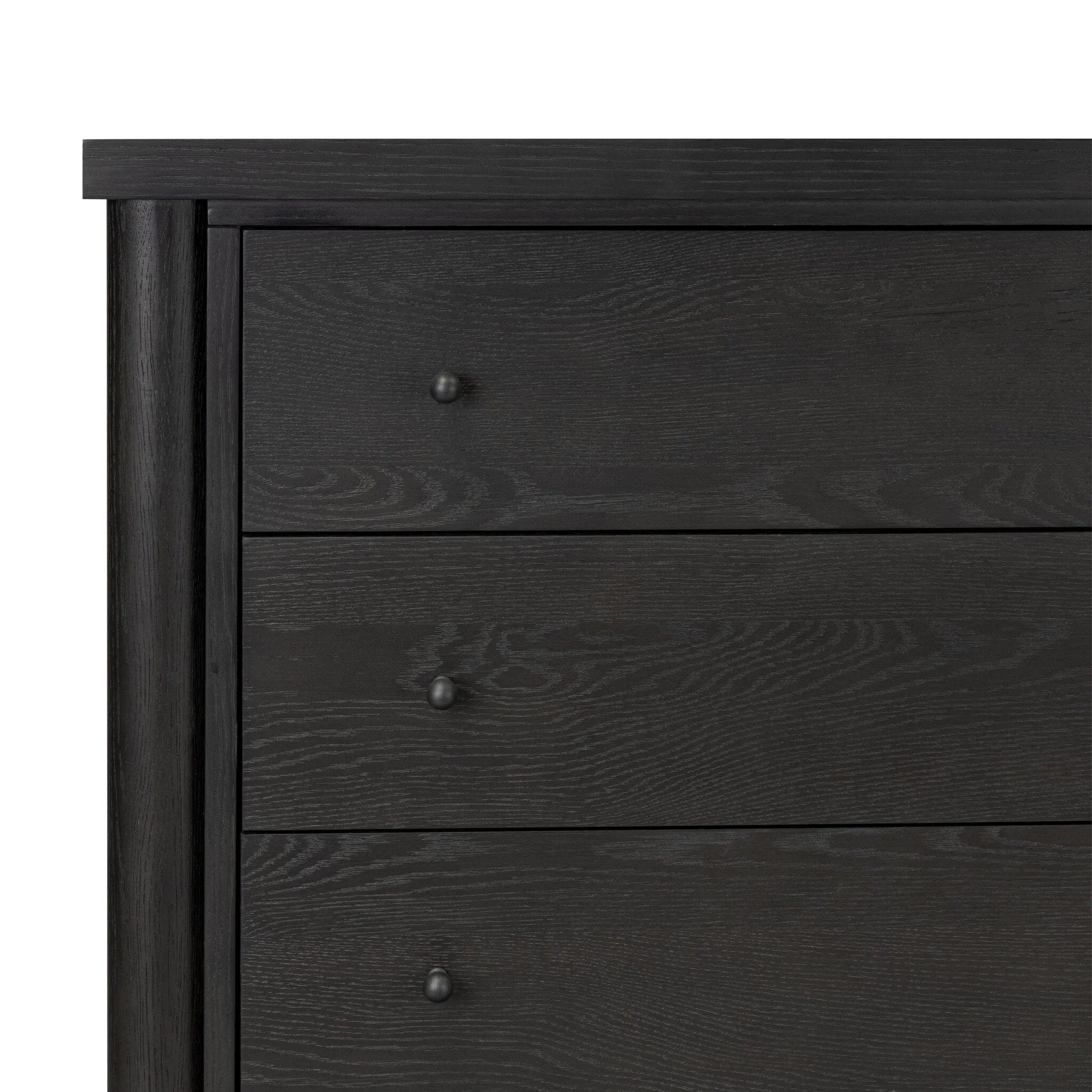 Create storage space in the bedroom with a five-drawer dresser of ebony-finished oak. Chunky dowel legs support a tall silhouette and overhang top, all finished out with simple gunmetal hardware Amethyst Home provides interior design, new home construction design consulting, vintage area rugs, and lighting in the Laguna Beach metro area.