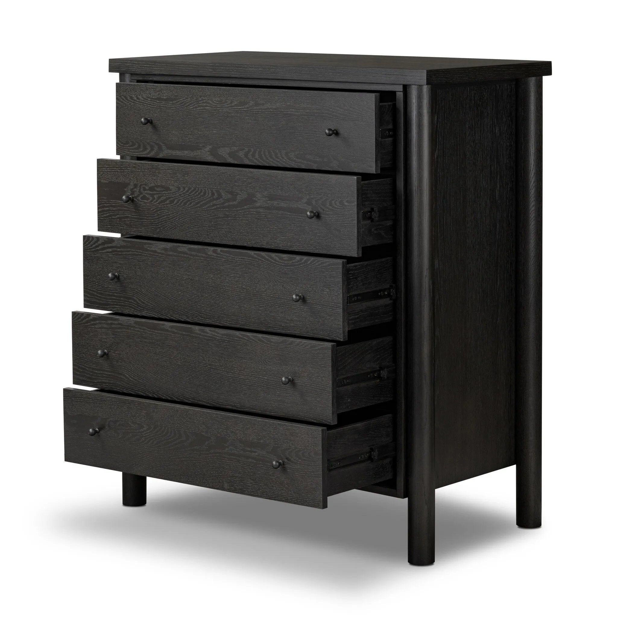 Create storage space in the bedroom with a five-drawer dresser of ebony-finished oak. Chunky dowel legs support a tall silhouette and overhang top, all finished out with simple gunmetal hardware Amethyst Home provides interior design, new home construction design consulting, vintage area rugs, and lighting in the Portland metro area.