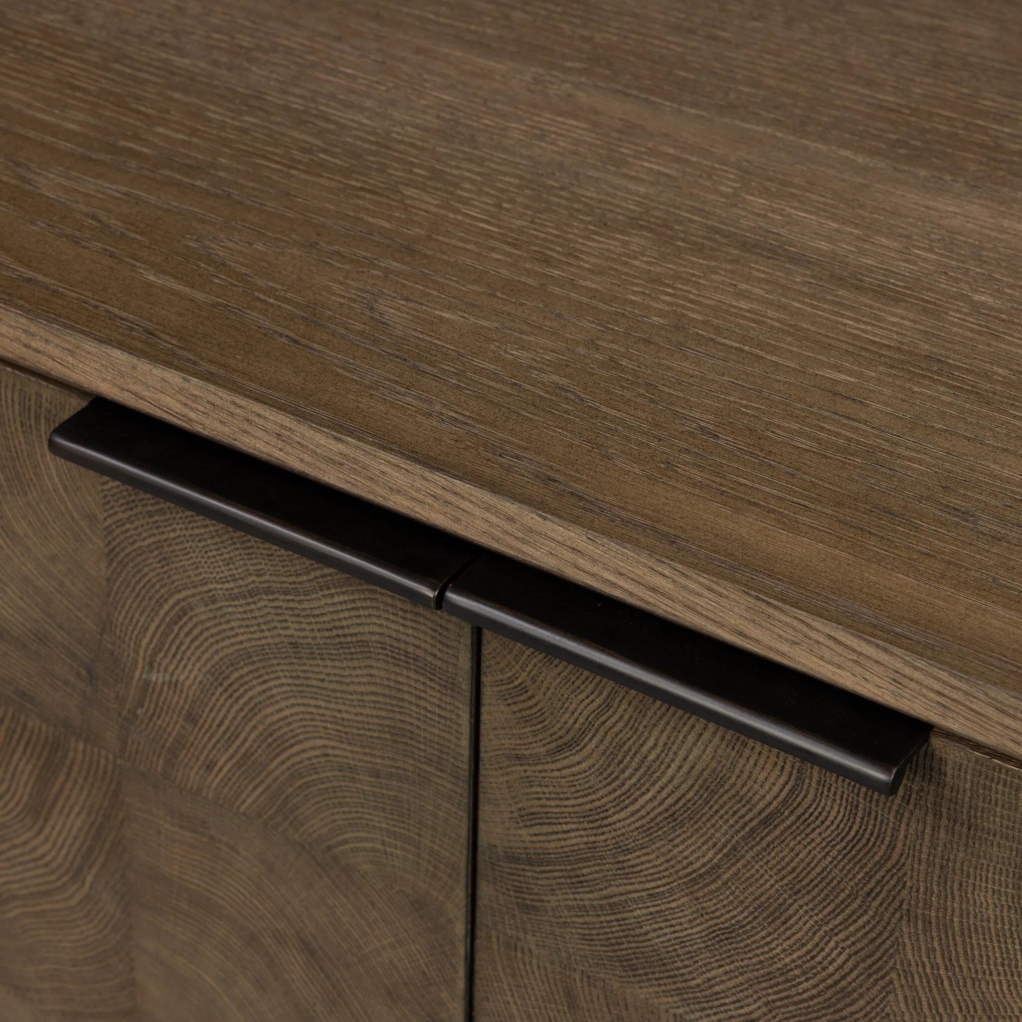 Grounding and stunning. We paired a modern frame and chunky base with door panels featuring oyster cuts of oak that take a specialized skill to create. Each cut captures the story of the wood and brings a natural, organic rhythm to the entire sideboard, and any space. Amethyst Home provides interior design, new home construction design consulting, vintage area rugs, and lighting in the Newport Beach metro area.