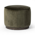 Upholstered in a deep olive velvet and paired with a rich brown base, this rounded ottoman can be placed just about anywhere.