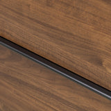 Dark brown walnut is aesthetically shaped with fluid, rounded corners on a ski leg base. The seamless design features six spacious drawers with metal bar hardware that runs along the tops of the drawers Amethyst Home provides interior design, new home construction design consulting, vintage area rugs, and lighting in the Kansas City metro area.