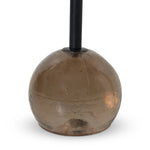 A sphere-shaped base of amber cast glass supports slim, black-finished iron piping and a tray-style tabletop that's perfectly sized to keep your favorite book or nightcap within reach Amethyst Home provides interior design, new home construction design consulting, vintage area rugs, and lighting in the Kansas City metro area.