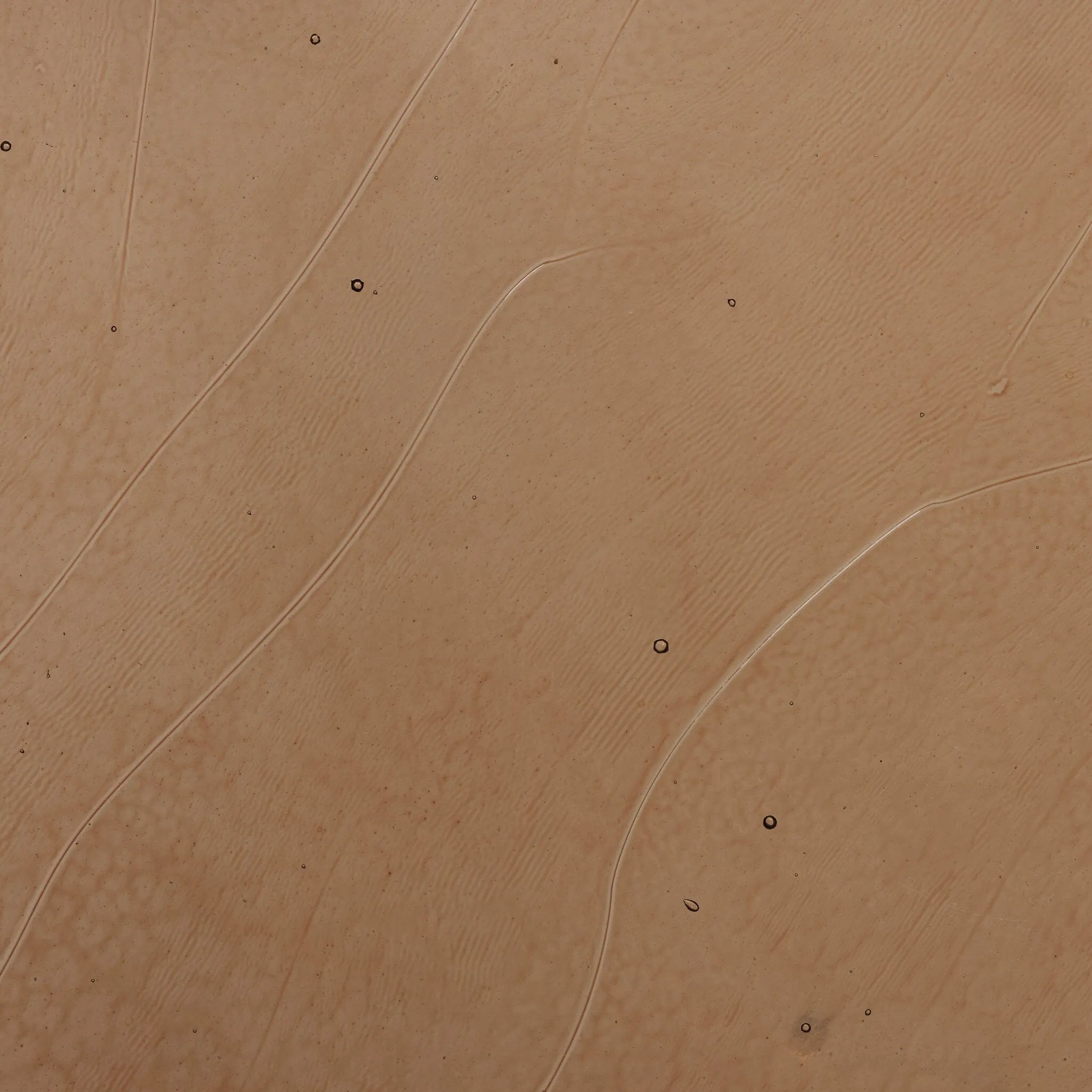 Smoky brown glass-topped table with slim, tapered matte black metal frames for a sleek, modern look. Part of a nesting set, c