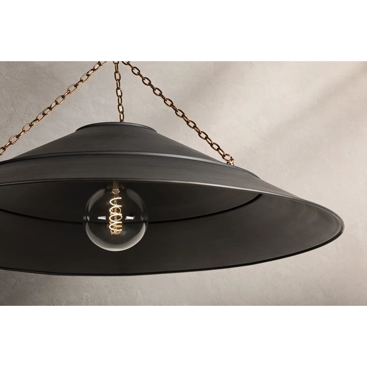 With its exposed metalwork, chain detailing, and unique finish combination, Arcane has an elevated, industrial vibe. The graphite shade feels chic and gives off a warm glow. The Patina Brass hardware, chain, and canopy add a hint of shine that plays wonderfully off the graphite. Amethyst Home provides interior design, new home construction design consulting, vintage area rugs, and lighting in the Los Angeles metro area.