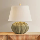 The Beata table lamp makes a sculptural, yet playful statement. A rounded ceramic base, finished in a Harbor Gray Crackle glaze, recalls the shape of a pumpkin. The elongated white linen shade balances the voluminous form, while Aged Brass hardware at the neck adds a polished note. Amethyst Home provides interior design, new home construction design consulting, vintage area rugs, and lighting in the Salt Lake City metro area.