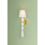 A celebration of authentic handicraft, the cinched silhouette of Indra resembles an elongated tassel. The cotton string and white linen shade create an all-over light, fresh appearance, accented by Aged Brass hardware at the neck. This single-light sconce serves as an artistic piece for small spaces in need of a spruce. Amethyst Home provides interior design, new home construction design consulting, vintage area rugs, and lighting in the Miami metro area.