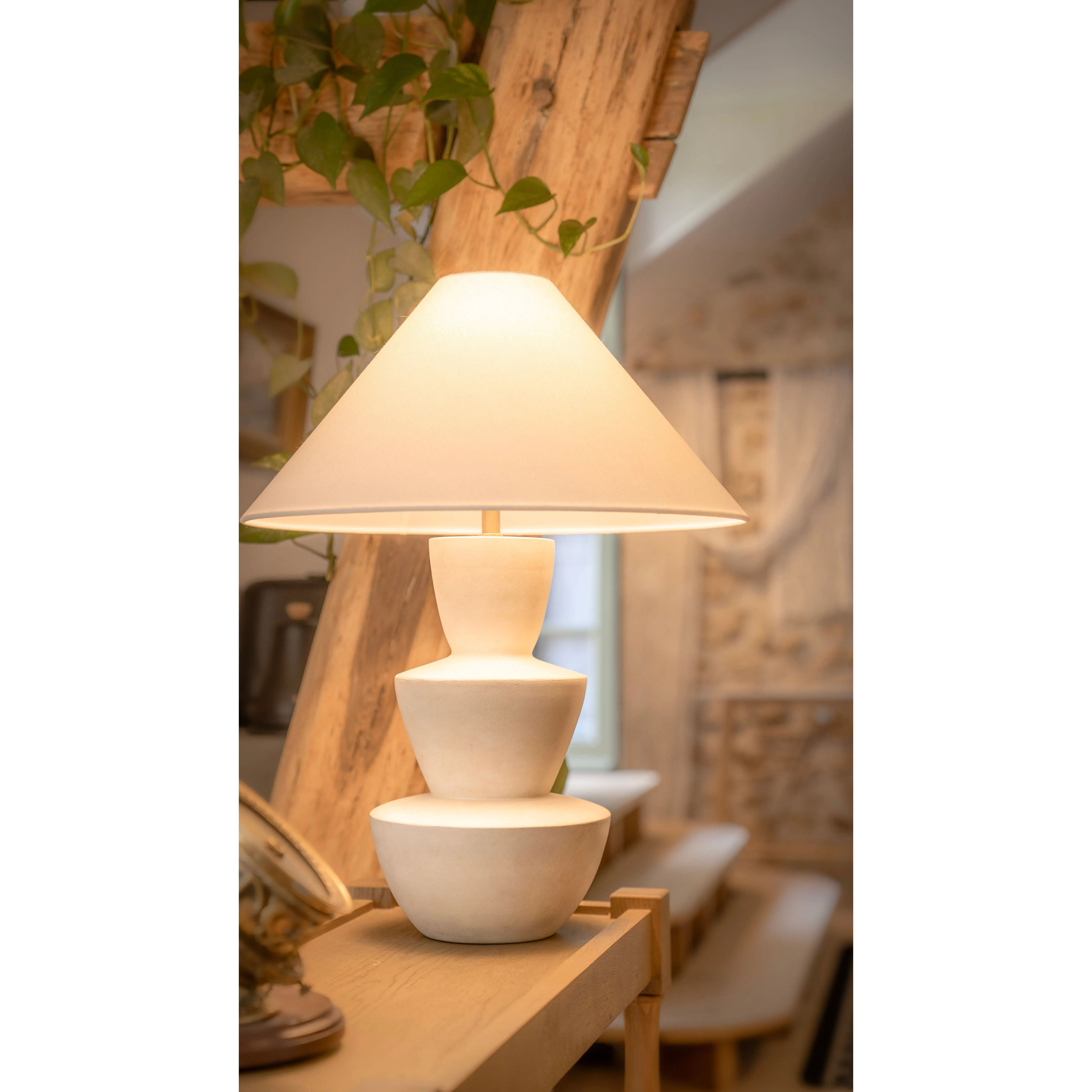 A series of three stacked, bowl-like shapes in ivory texture ceramic give this table lamp an organic, hand-crafted silhouette. The tapered off-white linen shade and Patina Brass accents add to the warm, natural beauty. Amethyst Home provides interior design, new home construction design consulting, vintage area rugs, and lighting in the Dallas metro area.
