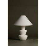 A series of three stacked, bowl-like shapes in ivory texture ceramic give this table lamp an organic, hand-crafted silhouette. The tapered off-white linen shade and Patina Brass accents add to the warm, natural beauty. Amethyst Home provides interior design, new home construction design consulting, vintage area rugs, and lighting in the Des Moines metro area.