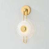 The earring-like design of Keuka Park exudes ornamental, graphic appeal. A thick disc of Blonchino Piastre glass is illuminated at the point where it attaches to the racetrack frame of this striking wall fixture. Whether finished in Aged Brass or Old Bronze, Keuka Park brings modernist artistry to any wall.  Amethyst Home provides interior design, new home construction design consulting, vintage area rugs, and lighting in the Calabasas metro area.