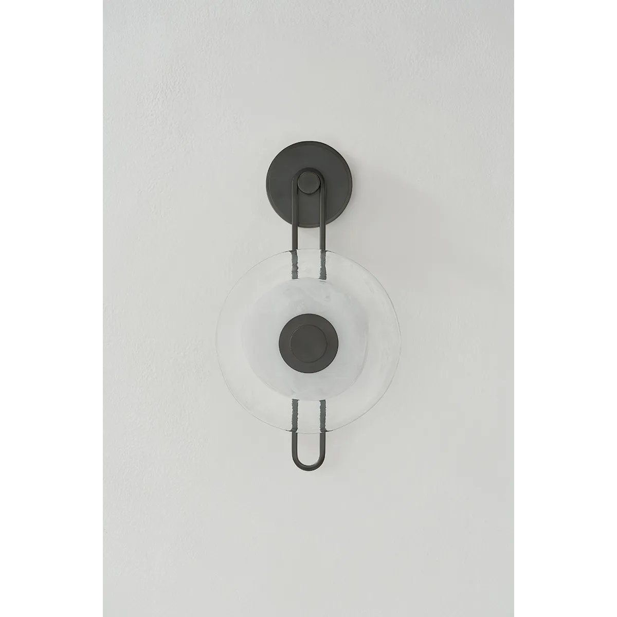 The earring-like design of Keuka Park exudes ornamental, graphic appeal. A thick disc of Blonchino Piastre glass is illuminated at the point where it attaches to the racetrack frame of this striking wall fixture. Whether finished in Aged Brass or Old Bronze, Keuka Park brings modernist artistry to any wall.  Amethyst Home provides interior design, new home construction design consulting, vintage area rugs, and lighting in the Miami metro area.