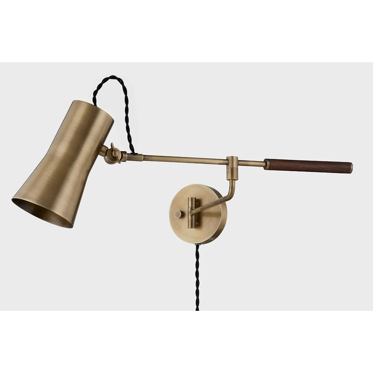 Tailored task lighting, this portable, functional swing arm sconce is also thoughtfully designed and beautiful. The sleek arm features a wooden handle on one end and an adjustable metal shade in Patina Brass or Bronze on the other. The twisted black cord detailing at the shade and backplate give Novel a nostalgic feel. Amethyst Home provides interior design, new home construction design consulting, vintage area rugs, and lighting in the Charlotte metro area.