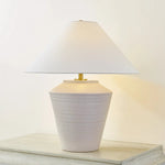 Inspired by raw beauty of the desert, this whitewashed terracotta table lamp is calm and refreshing. The textural body contrasts beautifully with the angular tapered white linen shade. An Aged Brass frame provides a surprising metallic finish. Part of THELIFESTYLEDCO® collection. Amethyst Home provides interior design, new home construction design consulting, vintage area rugs, and lighting in the Tampa metro area.