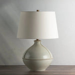 Inspired by rustic pottery, this table lamp's beautifully shaped base is crafted of pale sage ceramic giving it an earthy pale green tone. The off white linen shade pairs naturally and casts a soft glow. Raised seamlines and a reactive glaze that allows hints of the natural ceramic to peek through, give the fixture a hand-thrown, crafted feel. Amethyst Home provides interior design, new home construction design consulting, vintage area rugs, and lighting in the Portland metro area.