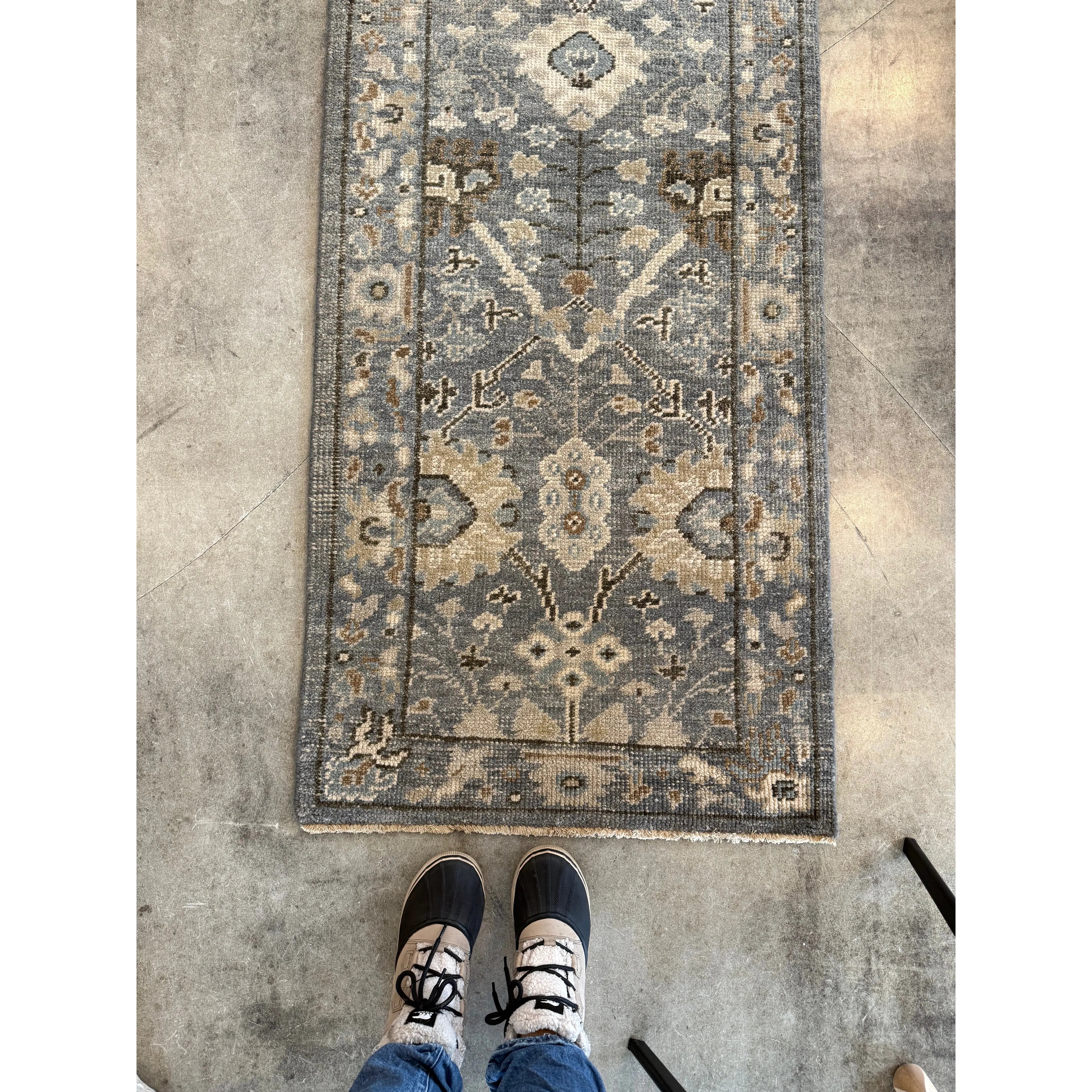 Decorative rug with intricate patterns on a concrete floor.