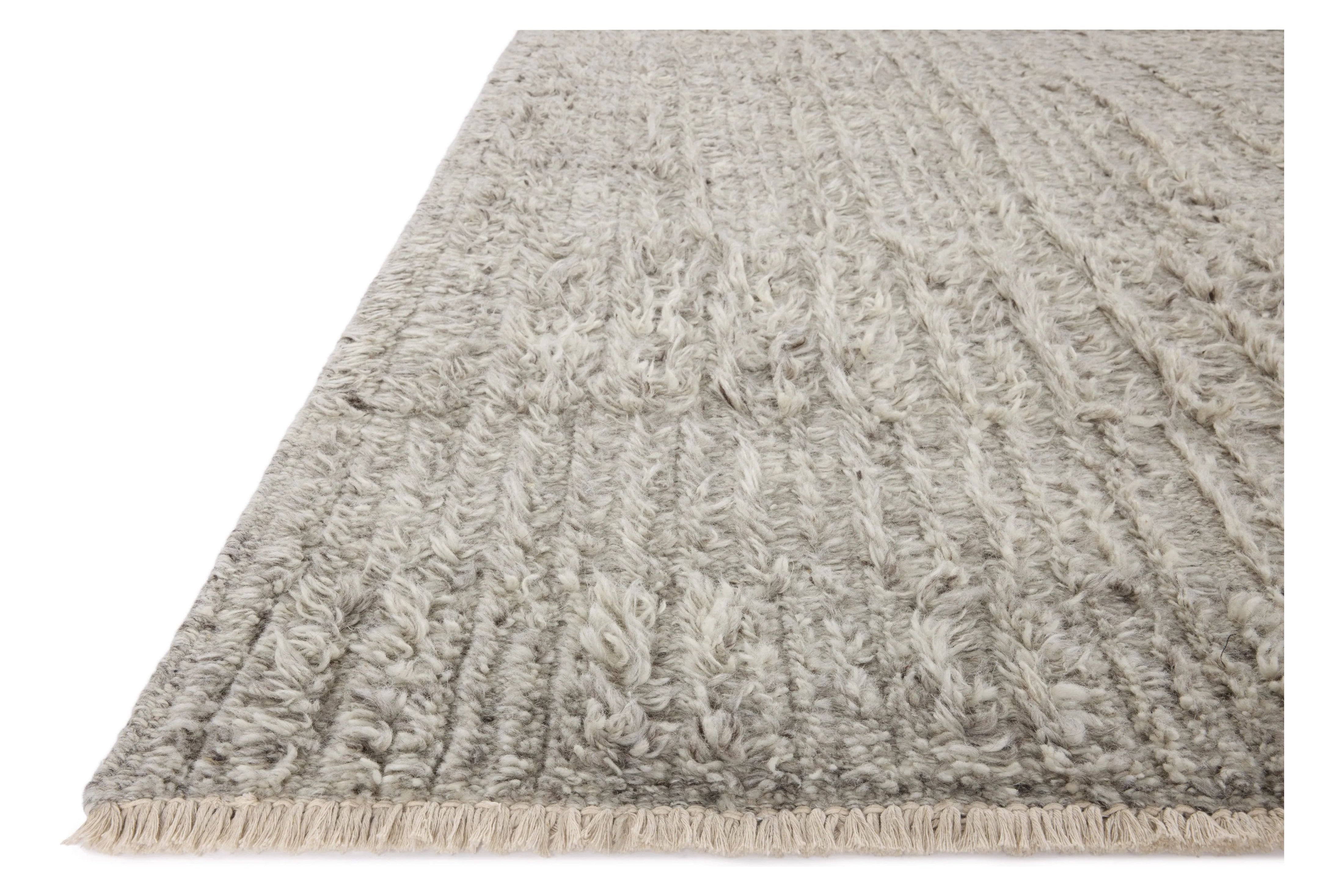 Irresistible to walk upon, the Dana Grey Rug by Brigette Romanek x Loloi has a high-low texture that alternates between a subtly shaggy pile and a soft base. Horizontal broken stripes give the area rug a fresh and energized structure, while a finish of fringe along the edges accentuates its sense of movement. Amethyst Home provides interior design, new home construction design consulting, vintage area rugs, and lighting in the Washington metro area.