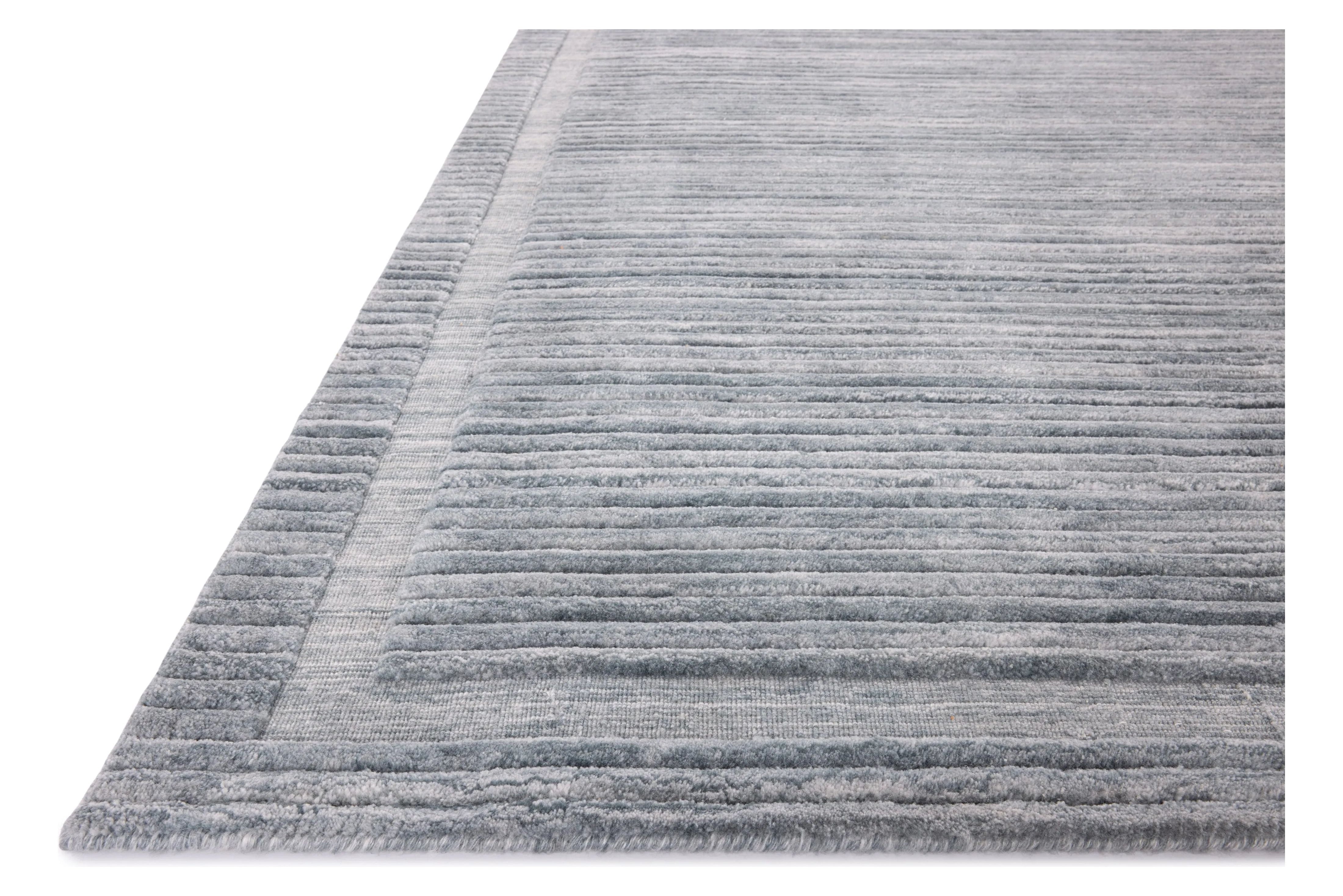 Irresistible to walk upon, the Dana Denim Rug by Brigette Romanek x Loloi has a high-low texture that alternates between a subtly shaggy pile and a soft base. Horizontal broken stripes give the area rug a fresh and energized structure, while a finish of fringe along the edges accentuates its sense of movement. Amethyst Home provides interior design, new home construction design consulting, vintage area rugs, and lighting in the Alpharetta metro area.