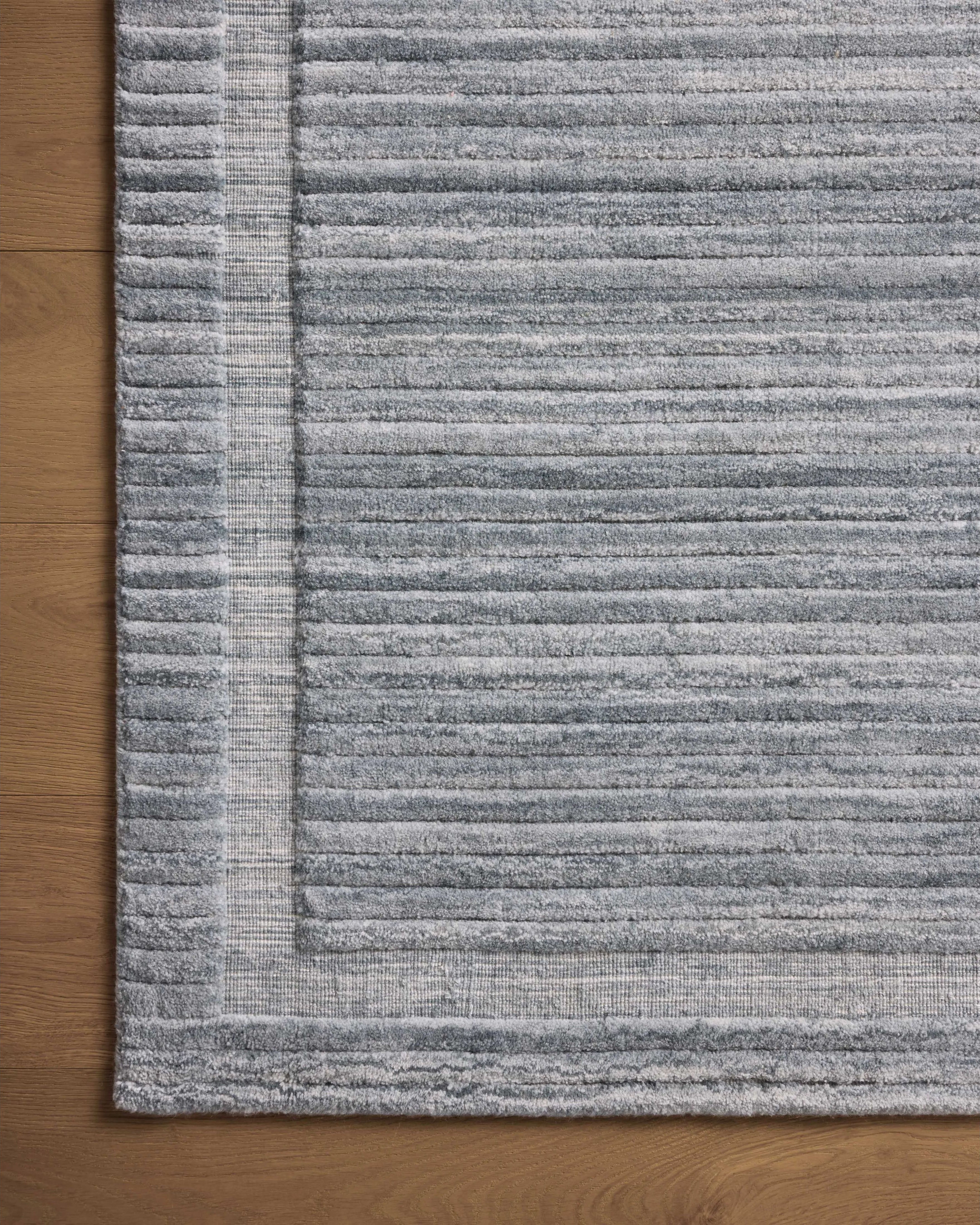 Irresistible to walk upon, the Dana Denim Rug by Brigette Romanek x Loloi has a high-low texture that alternates between a subtly shaggy pile and a soft base. Horizontal broken stripes give the area rug a fresh and energized structure, while a finish of fringe along the edges accentuates its sense of movement. Amethyst Home provides interior design, new home construction design consulting, vintage area rugs, and lighting in the Des Moines metro area.
