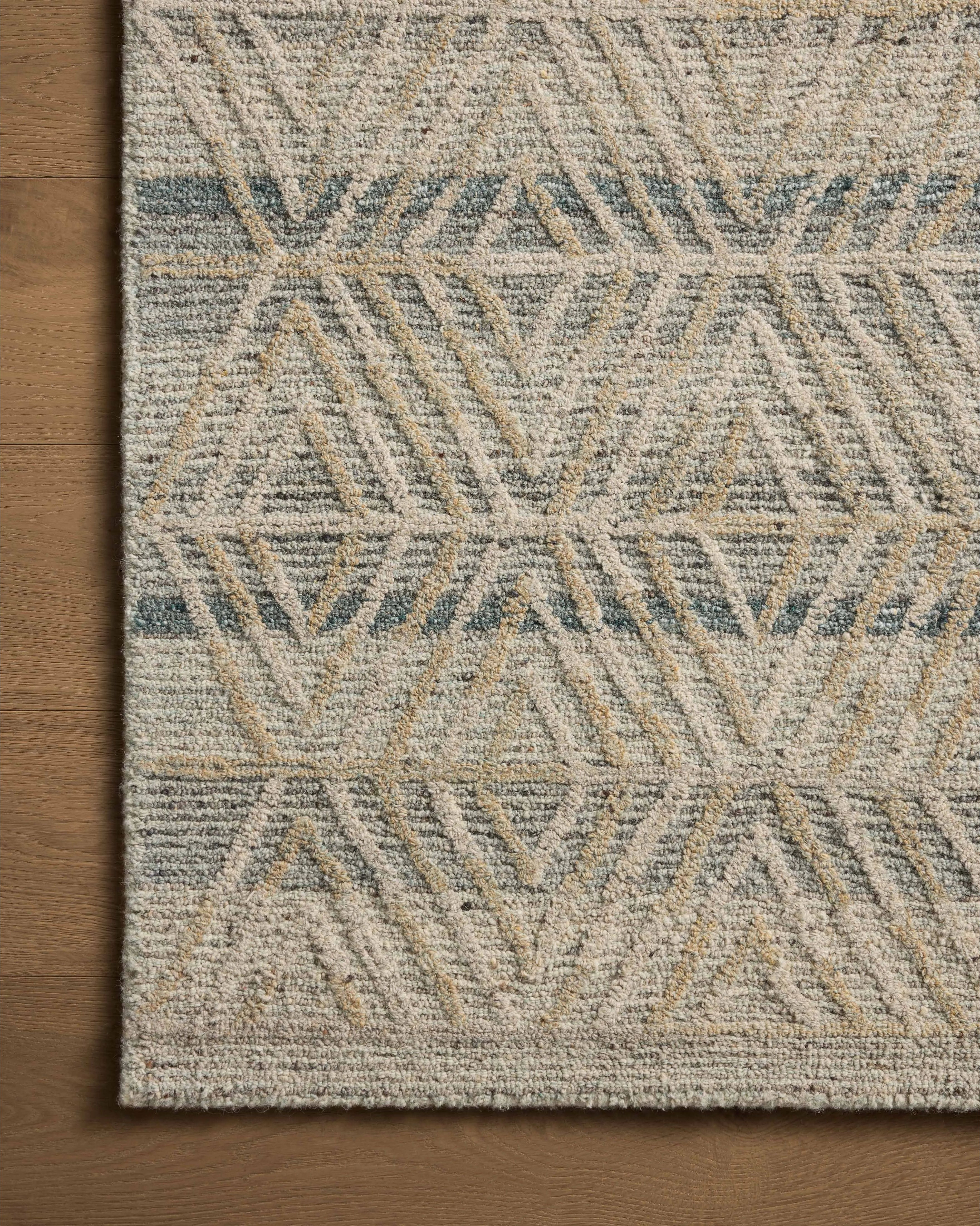 The Elias Fog / Natural Rug is a hand-tufted wool area rug with lively graphic patterns in earth and stone tones. There’s a unique texture to the rug made by over-tufting, in which a design is hand-tufted over a tufted base, creating a subtle high-low pile. Amethyst Home provides interior design, new home construction design consulting, vintage area rugs, and lighting in the Charlotte metro area.