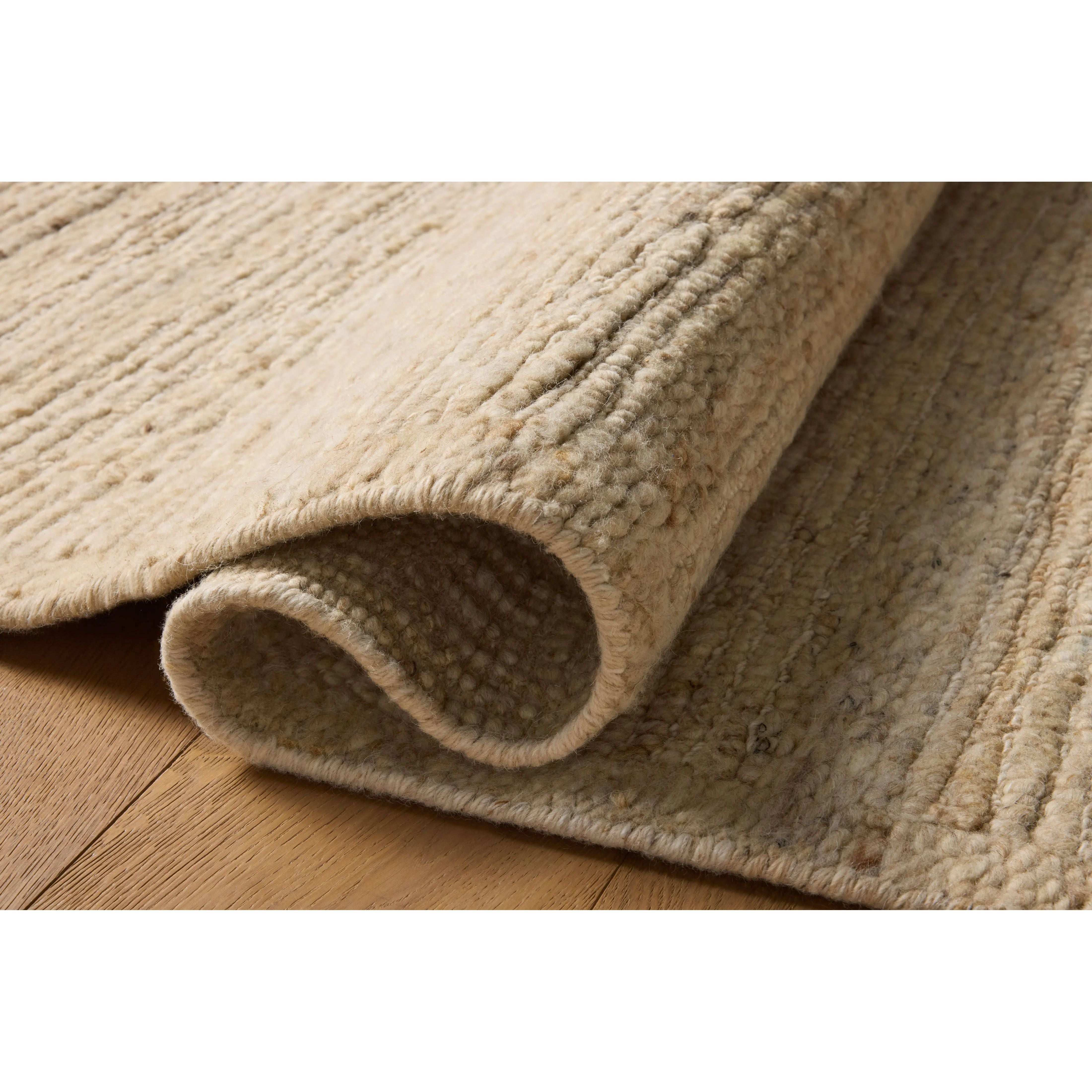 The Lennox Collection by Leanne Ford x Loloi is a statement area rug made with natural undyed wool that reveals subtle color differentiation in creamy neutral tones. The rug is hand-woven with a labor-intensive soumak weave, alternating rows of thick and thin looped yarns for an organic, inviting texture. Amethyst Home provides interior design, new home construction design consulting, vintage area rugs, and lighting in the Nashville metro area.