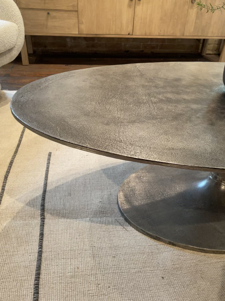 We love the oval shape of this Simone Coffee Table - Antique Nickel. The textural cast aluminum makes for a beautifully modern coffee table, with alluring highs and lows played up by a raw nickel finish. Great indoors or out; cover or store indoors during inclement weather and when not in use.  Overall Dimensions: 54.75"w x 29.25"d x 16.50"h