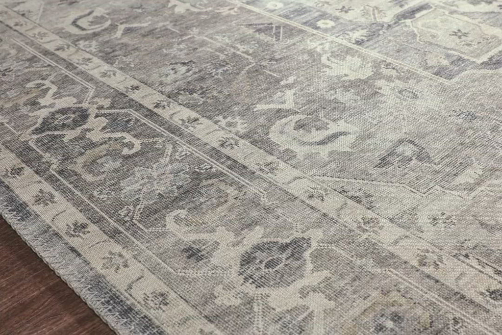 Featuring soft motifs in a carefully curated color palate of grey, black, ivory and hints of blue, the Hathaway Steel / Ivory area rug captures the essence of one-of-a-kind vintage or antique area rug at an attractive price.