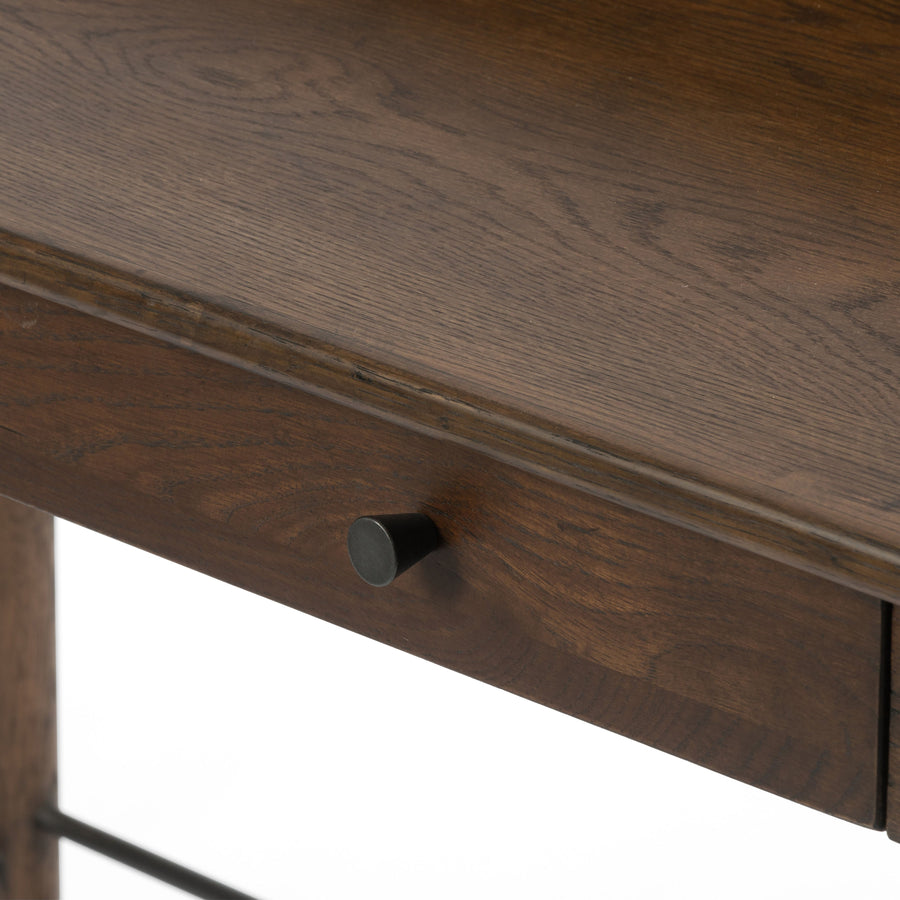 Dark-toasted oak's rich brown finish speaks to mid-century inspiration, while plenty of storage meets the needs of a modern office with this Moreau Dark Toasted Oak Writing Desk.   Overall Dimensions: 48"w x 23.5"d x 34.75"h