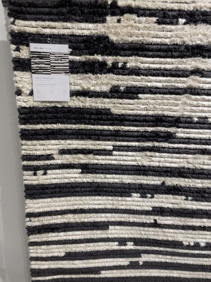 Durable, graphic, and soft underfoot, this rug is inspired by the classic Moroccan rug. The Alice Chris + Julia Cream / Charcoal ALI-03 rug features a high-low texture with warm earthy colors with a subtle fringe. The rug is easy to clean and maintain and perfect for living rooms, dining rooms, hallways, and kitchens!