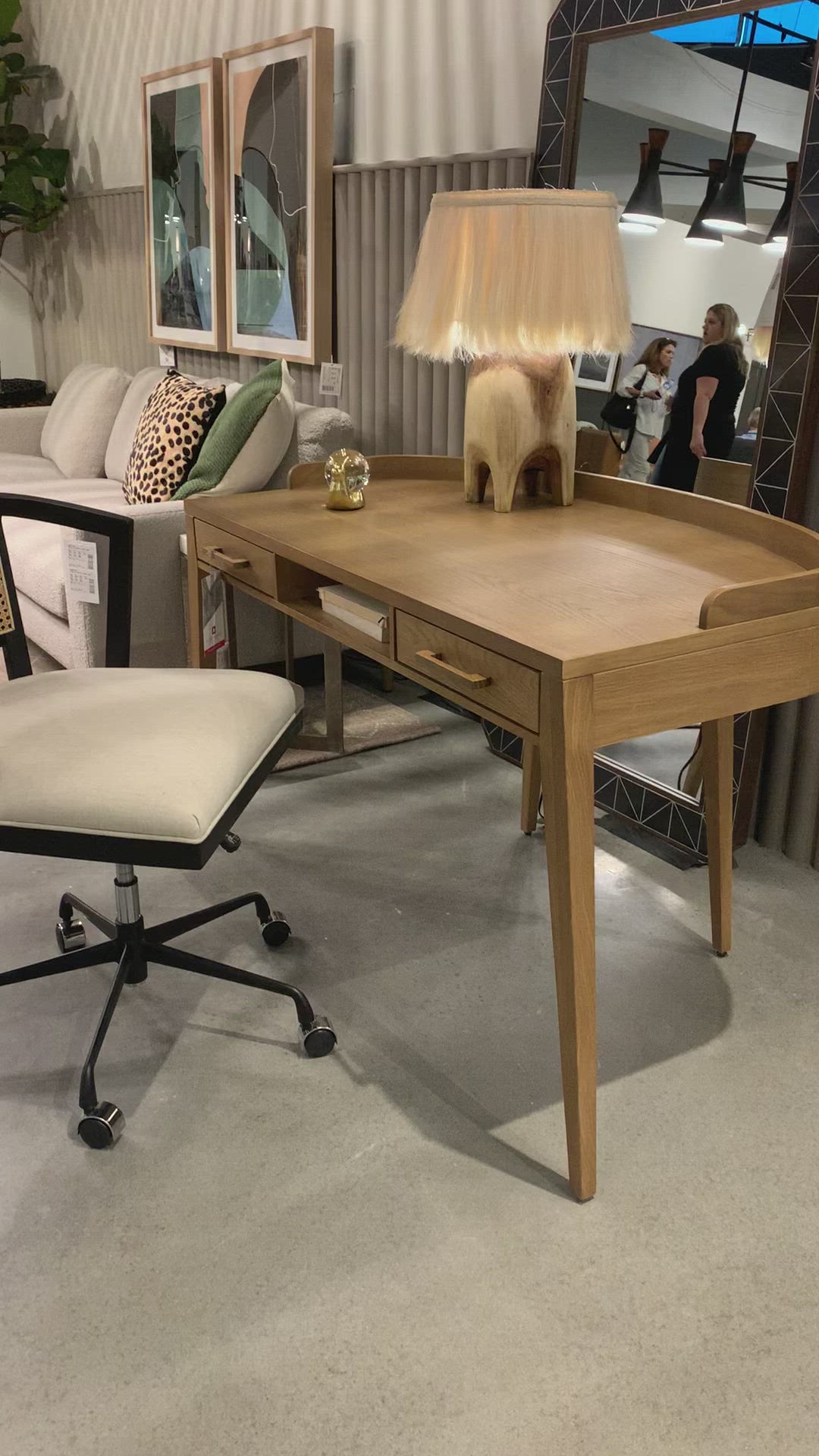 With dramatically tapered legs and a slender silhouette, this Armstrong Desk - Burnished Oak is made of light-burnished oak and places a femme, functional twist on mid-century styling. Dual drawers plus an open center cubby for handy office supply storage.  Overall Dimensions: 55.50"w x 27.00"d x 32.00"h