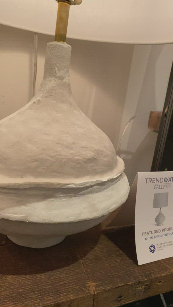 Inspired by a paper maché bowl, this versatile lamp is at home in a variety of spaces. Complex curves, paired with a matte white finish gives this table a unique appearance. Slight imperfections were left in, adding beauty and originality.  Size: 14"w x 14"d x 23.5"h