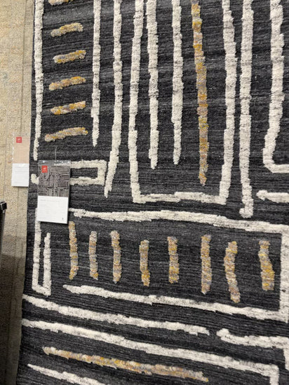 The Naomi Charcoal / Natural Area Rug is hand-knotted of wool and cotton by artisans in India. Naomi offers bold designs with earthy hues and features a high-low pile that adds depth and dimension, making each piece create the illusion of movement. A perfect rug for your living room, entryway, or other  Hand Knotted 89% Wool | 11% Cotton NAO-05 Charcoal/Natural