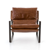 Featuring Emmett Sling Chair - Leather by Four Hands at Amethyst Home. Super stylish, effortlessly cool. Sling-style seating of tobacco-toned leather sits low and curved for a fresh take on a throwback form. Slim, gunmetal-finished iron framing ups the drama factor of an innately hip design.
Overall Dimensions: 29"W x 36"L x 29"HColors: Dakota Tobacco, Gun.  Amethyst Home provides interior design, new home construction design consulting, vintage area rugs, and lighting in the San Diego metro area.