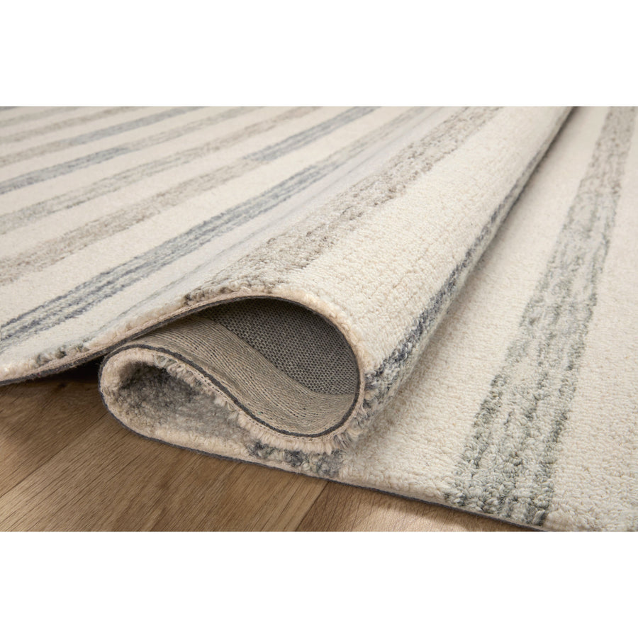 Known for its durability, the Chris Ivory / Slate hooked wool rug is a smart choice for any room in your home that gets lots of love. The subtle, tonal stripes remind us of our favorite California cool hemp rugs. Amethyst Home provides interior design services, furniture, rugs, and lighting in the Dallas metro area.