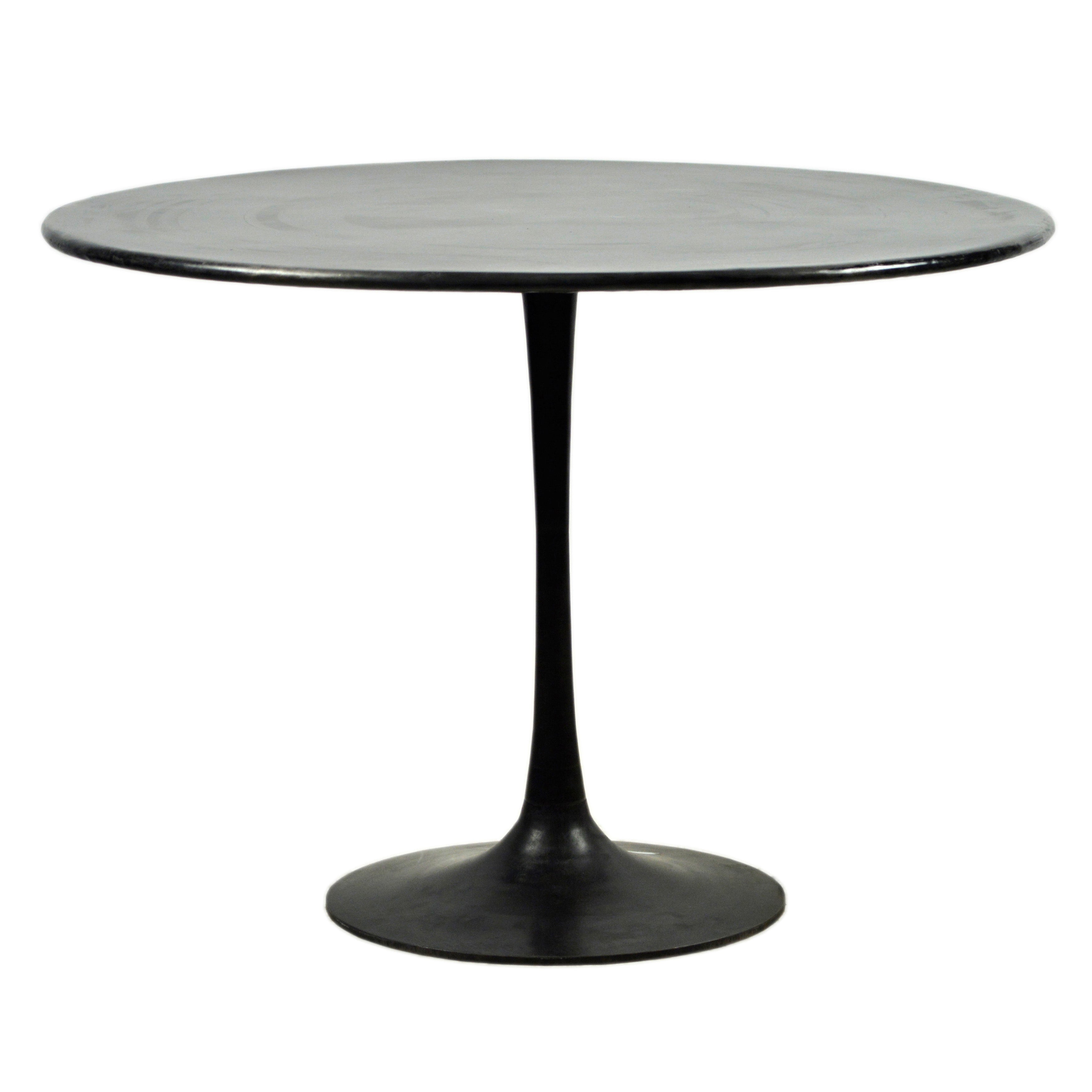 Enhance your home decor with the perfect blend of modern and industrial styles embodied in this timeless tulip table. Designed to showcase your favorite homemade meals, it features a captivating flared pedestal base crafted from iron, adorned with a deep black antique finish that adds a bold and modernistic edge to your space. Amethyst Home provides interior design, new home construction design consulting, vintage area rugs, and lighting in the Winter Garden metro area.