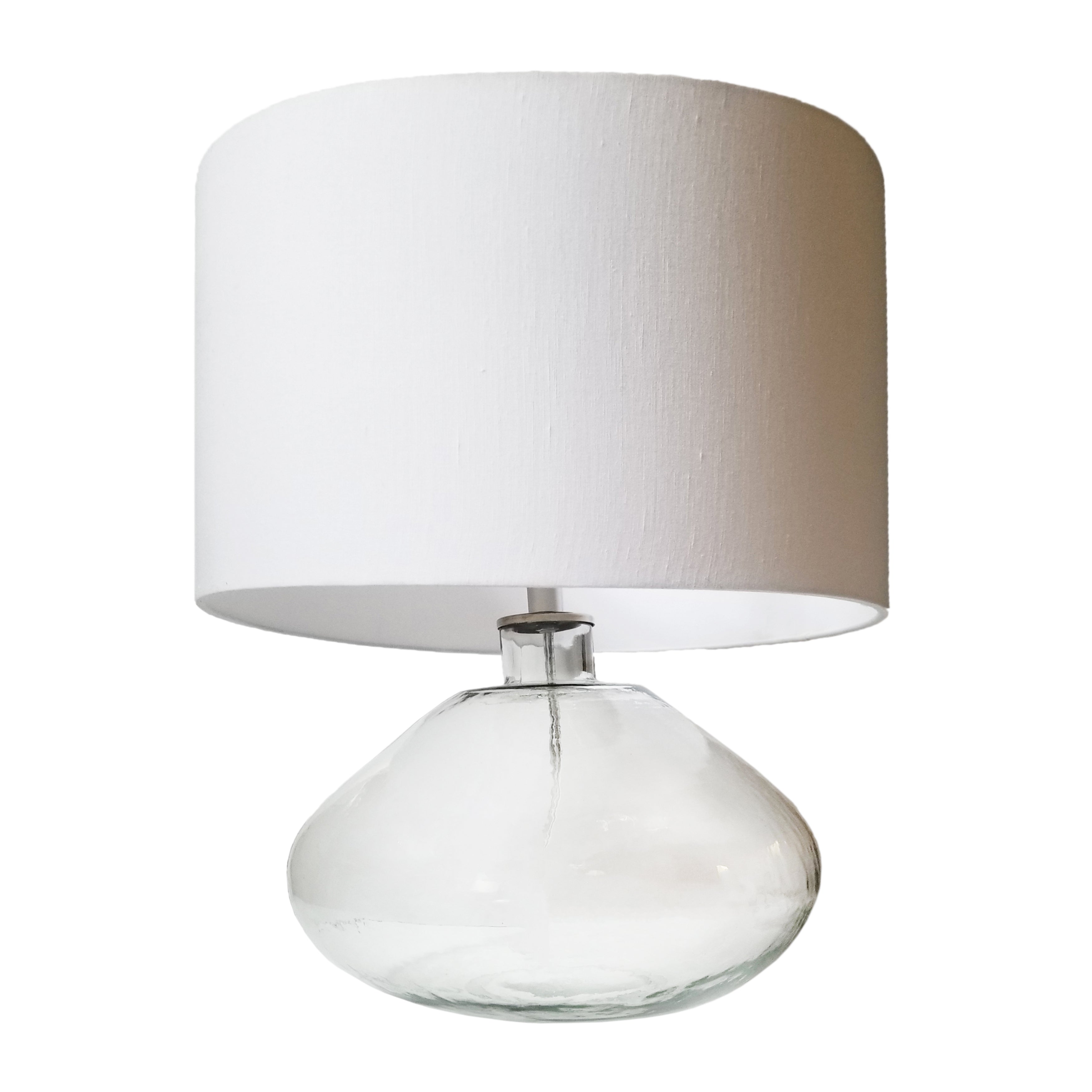 A modern take on a classic design, this shapely table lamp pairs easily with both minimalist and maximalist décor. This table lamp features a white linen shade with a hand-blown glass base. A classic, versatile addition to any décor theme, this accent light is beautiful placed on a nightstand, side table, or desk for additional lighting. Amethyst Home provides interior design, new home construction design consulting, vintage area rugs, and lighting in the Monterey metro area.