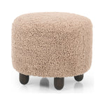 Place this round ottoman just about anywhere. Upholstered in a faux Mongolian shearling with a high pile fur in a toasty tan neutral hue. Burnt birch parawood legs add a touch of contrast.Collection: Kensingto Amethyst Home provides interior design, new home construction design consulting, vintage area rugs, and lighting in the Austin metro area.