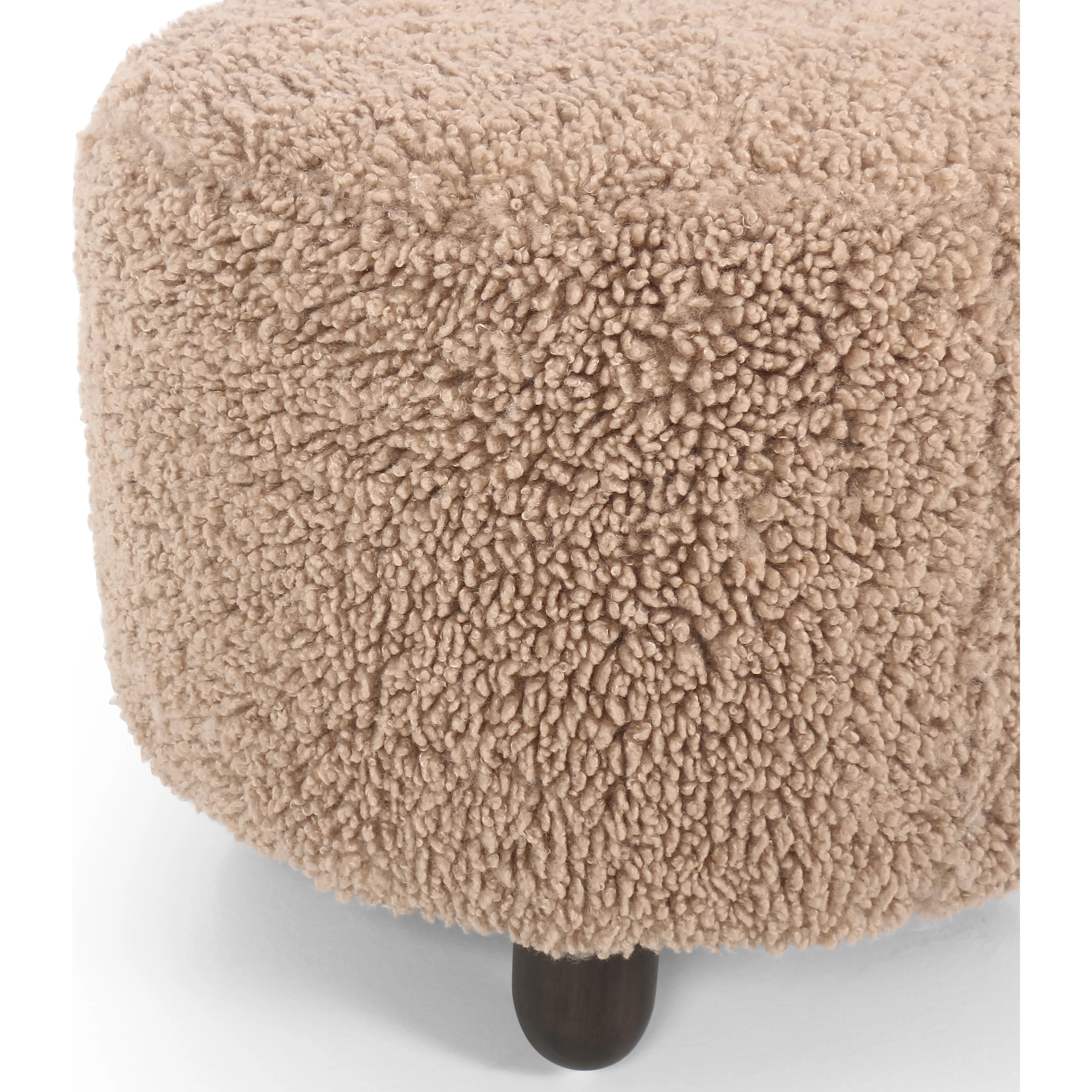 Place this round ottoman just about anywhere. Upholstered in a faux Mongolian shearling with a high pile fur in a toasty tan neutral hue. Burnt birch parawood legs add a touch of contrast.Collection: Kensingto Amethyst Home provides interior design, new home construction design consulting, vintage area rugs, and lighting in the Winter Garden metro area.