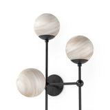 Marbled glass spheres seem to extend and reach across smooth brass rods. Each globe is individually blown, shaped and sculpted by hand through a one-hour process. The finish on the brass frame is achieved through a specialized process that turns the brass into an almost black hue before the rod is polished smooth. Amethyst Home provides interior design, new home construction design consulting, vintage area rugs, and lighting in the Salt Lake City metro area.