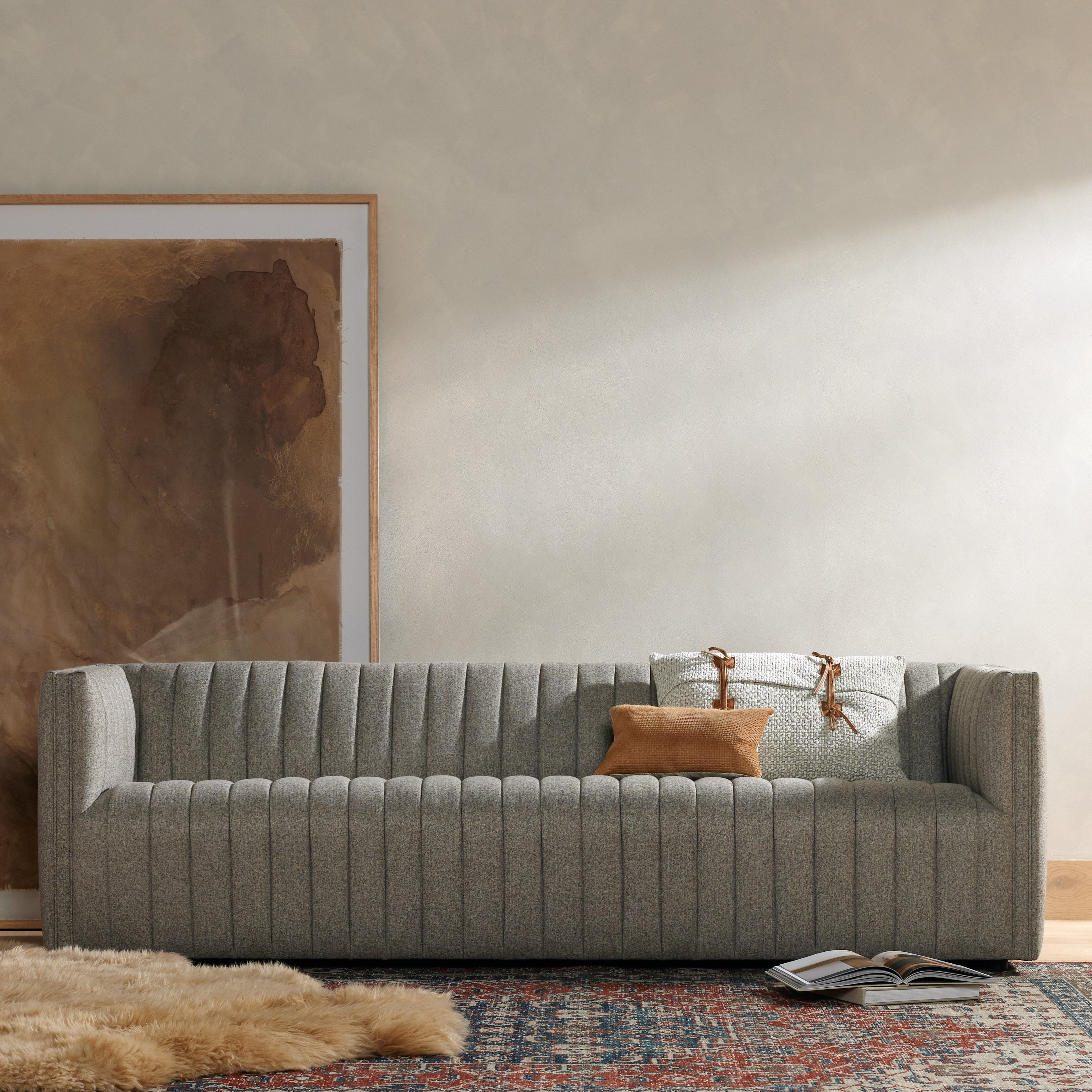 A dramatically channeled sofa with textural grey upholstery offers a clean look inspired by modern menswear. Amethyst Home provides interior design, new construction, custom furniture, and area rugs in the Omaha metro area.
