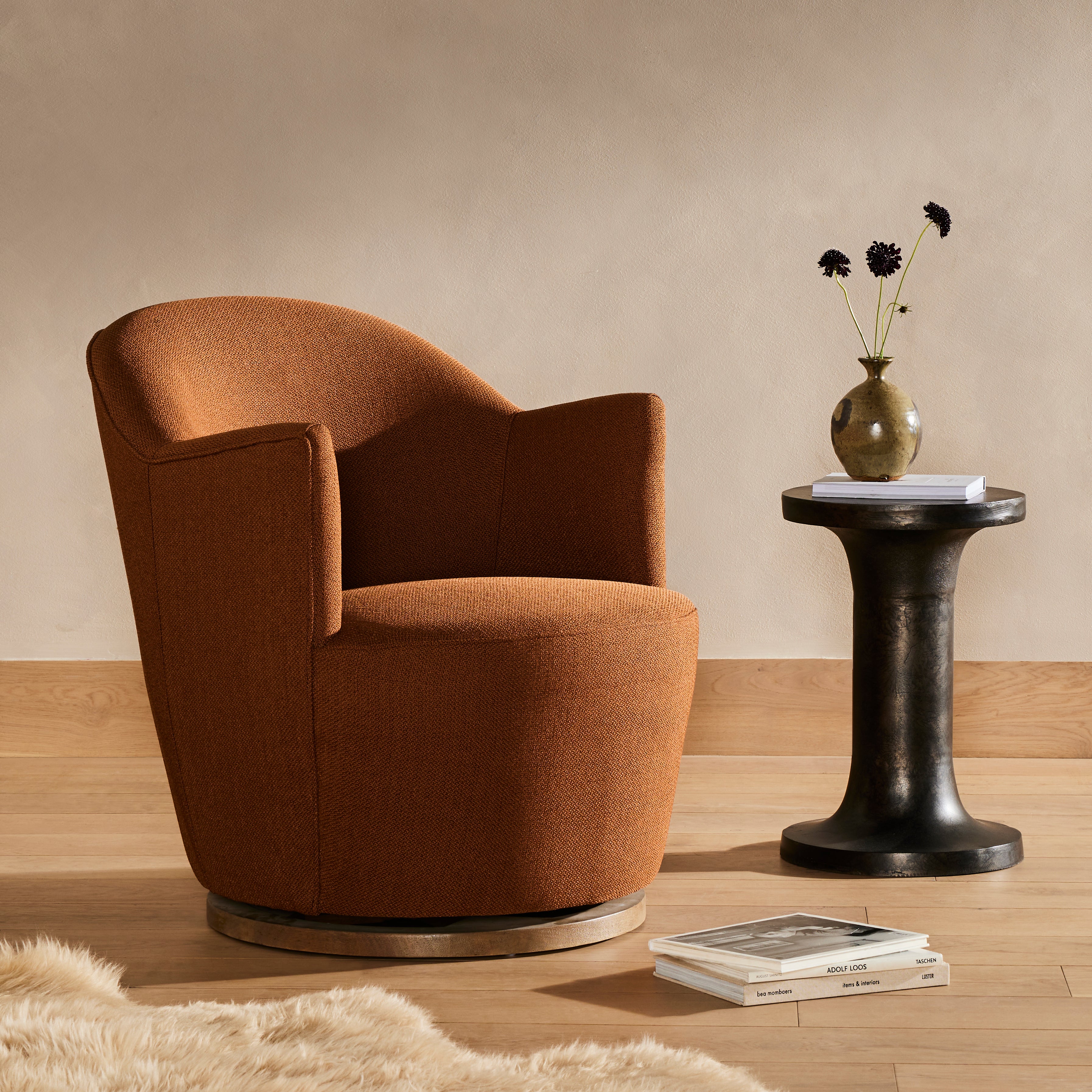 Intriguing while inviting. Drum-style seating is upholstered in a soothing and warm rust umber hue. A swivel base of natural parawood places a fresh spin on a feminine form. Amethyst Home provides interior design, new construction, custom furniture, and area rugs in the Omaha metro area.