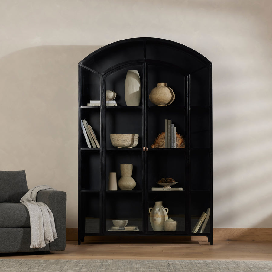 Display barware, books and keepsakes in wide, beautifully arched cabinetry. Solid iron sheeting is finished in a soft, matte black with contrasting brass hardware. Amethyst Home provides interior design, new construction, custom furniture, and area rugs in the Tampa metro area.