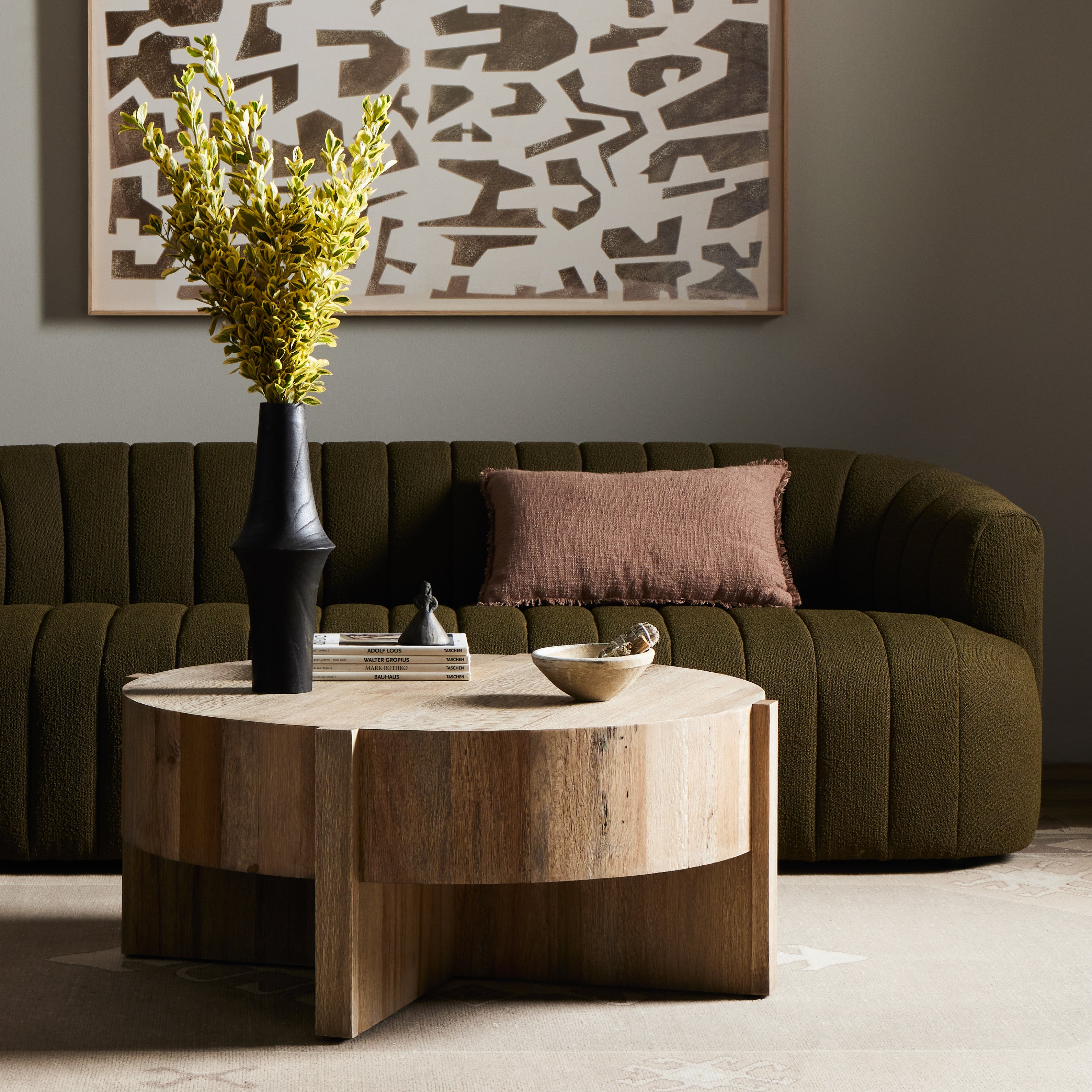 An organic-spirited statement piece. A drum-style coffee table of character-rich oak and veneers rests within a sculptural cradle base of matching rustic oak with beautiful highs and lows. Amethyst Home provides interior design, new construction, custom furniture, and area rugs in the Seattle metro area.