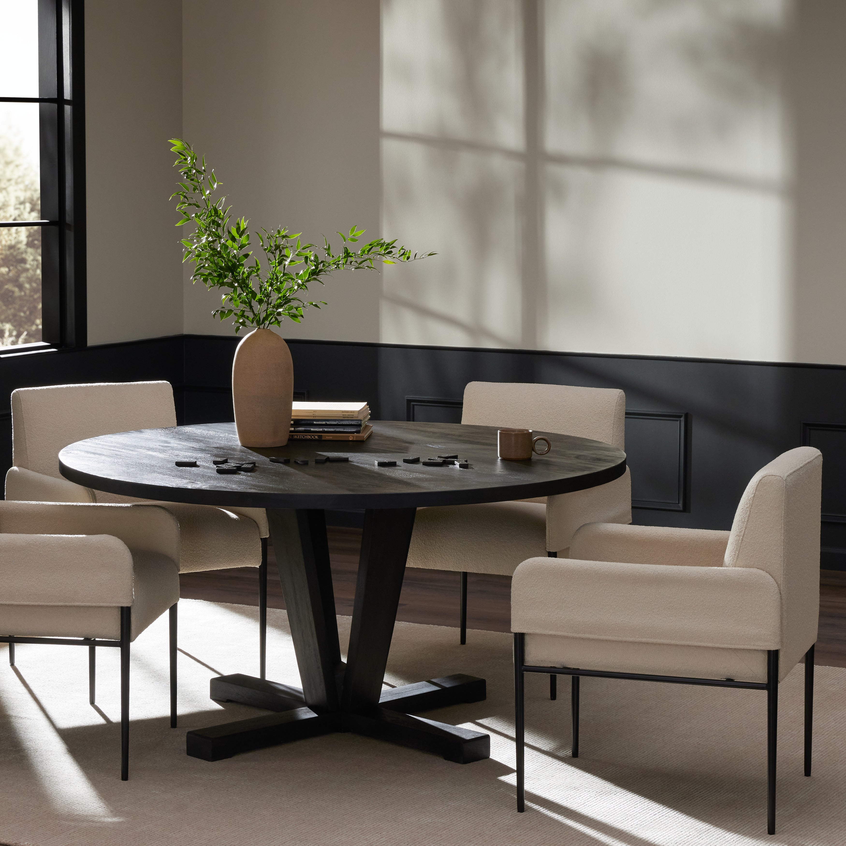 A rounded table of solid mango wood forms purposefully burnished edges, producing a warm black patina for the home dining table. Amethyst Home provides interior design, new construction, custom furniture, and area rugs in the Kansas City metro area.