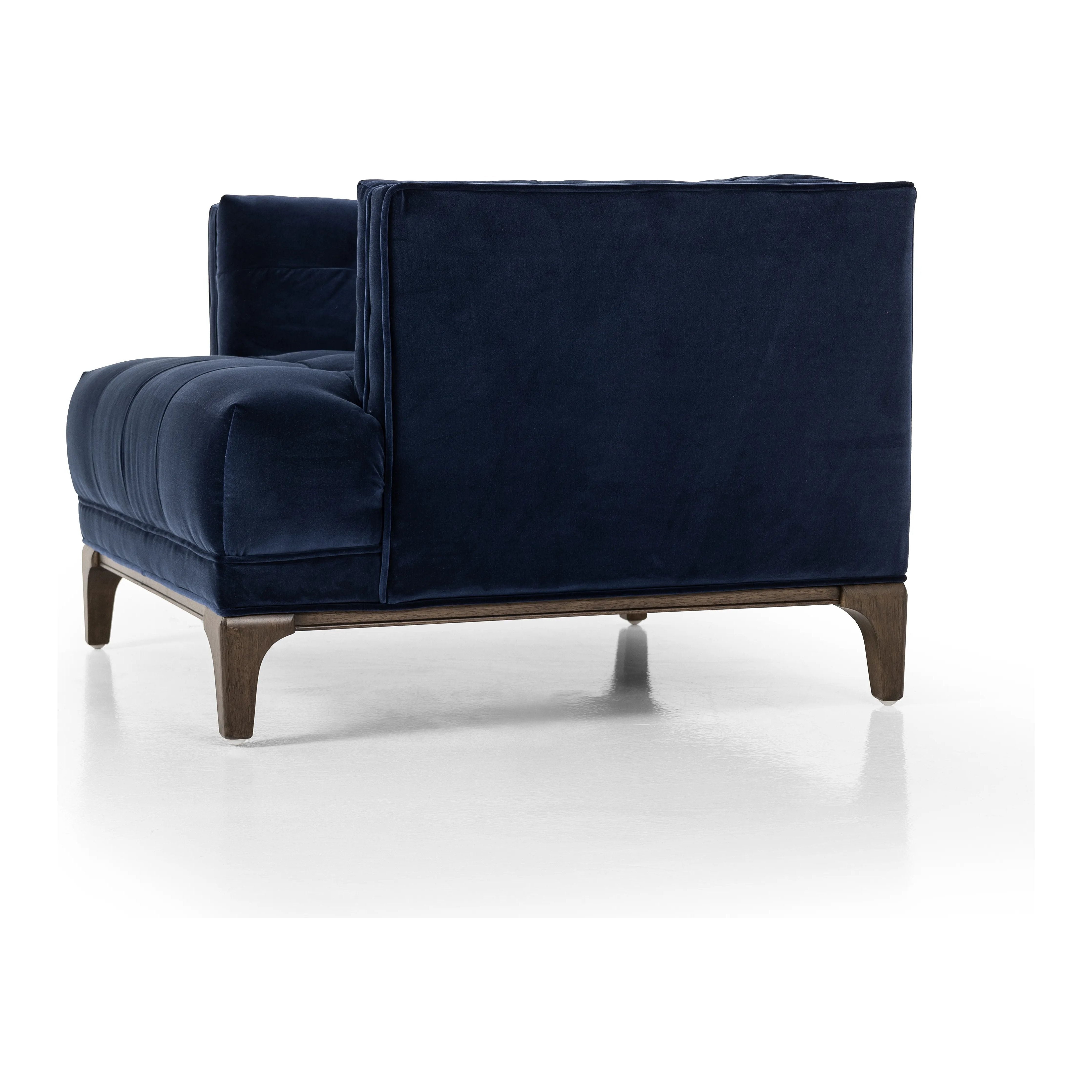 This low, tailored midcentury silhouette is upholstered in a velvety navy fabric, with dramatic blind tufting for texture.Collection: Kensingto Amethyst Home provides interior design, new home construction design consulting, vintage area rugs, and lighting in the Charlotte metro area.