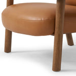 Sleek and inviting, this wood-meets-leather arm chair is timeless in any context. Large cylindrical legs support the upholstered back and seat, which are covered in camel-colored top-grain leather. Spring suspension adds comfort and durability to the seat cushion.Collection: Carnegi Amethyst Home provides interior design, new home construction design consulting, vintage area rugs, and lighting in the Newport Beach metro area.