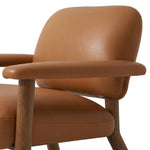 Sleek and inviting, this wood-meets-leather arm chair is timeless in any context. Large cylindrical legs support the upholstered back and seat, which are covered in camel-colored top-grain leather. Spring suspension adds comfort and durability to the seat cushion.Collection: Carnegi Amethyst Home provides interior design, new home construction design consulting, vintage area rugs, and lighting in the Omaha metro area.
