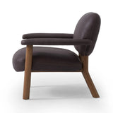 Sleek and inviting, this wood-meets-leather arm chair is timeless in any context. Large cylindrical legs support the upholstered back and seat, which are covered in bark-colored top-grain leather. Spring suspension adds comfort and durability to the seat cushion.Collection: Carnegi Amethyst Home provides interior design, new home construction design consulting, vintage area rugs, and lighting in the Alpharetta metro area.