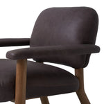 Sleek and inviting, this wood-meets-leather arm chair is timeless in any context. Large cylindrical legs support the upholstered back and seat, which are covered in bark-colored top-grain leather. Spring suspension adds comfort and durability to the seat cushion.Collection: Carnegi Amethyst Home provides interior design, new home construction design consulting, vintage area rugs, and lighting in the Omaha metro area.