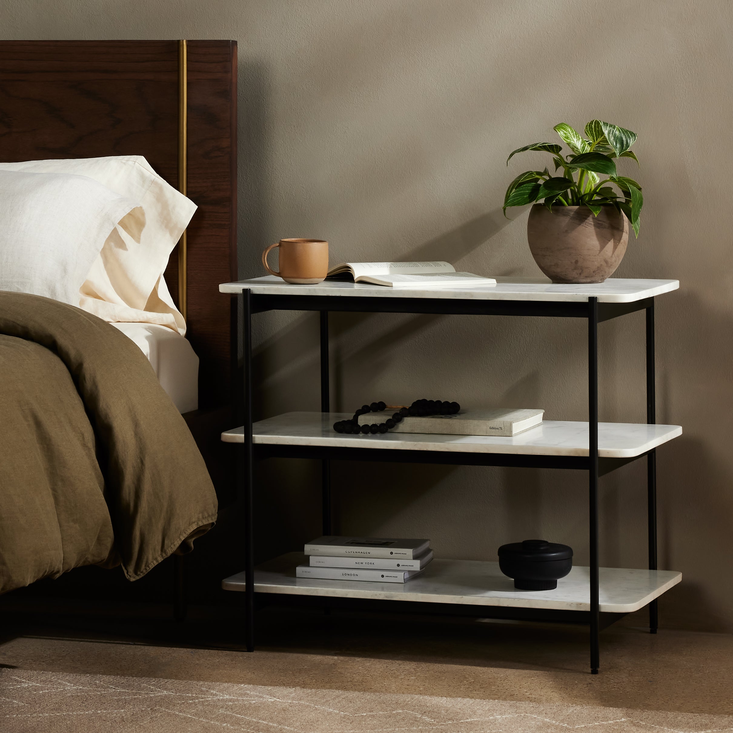 Jasper Nightstand is a black-finished iron that forms a slim, airy frame for open shelving of polished white marble. Amethyst Home provides interior design services, furniture, rugs, and lighting in the Calabasas metro area.